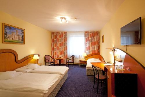捷克布杰约维采萨沃伊酒店的酒店客房设有两张床和一张桌子。