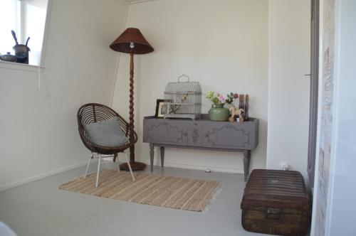 卡斯特里科姆Bijzonder Bakkum的一间带椅子和一张桌子及台灯的房间