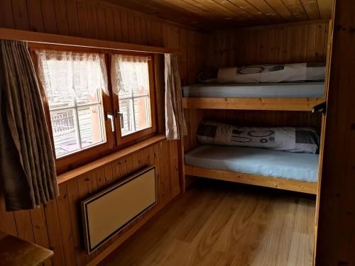 瓦尔斯B&B Gassa 95的小屋设有两张双层床和一扇窗户。