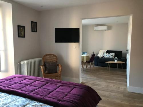 图尔尼LA MAISON DE MARION的一间带紫色床的卧室和一间客厅