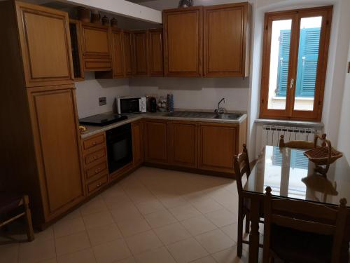 里奥马哲雷Ca' dei Nogi - Appartamento a Riomaggiore的厨房配有木制橱柜、桌子和窗户。