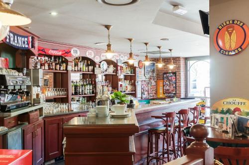 马洛塞讷Hôtel-Restaurant Le Blueberry的一间设有木柜和酒吧凳的酒吧