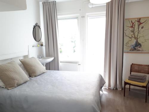 莱顿Tiny Monumental House in Down Town Leiden的卧室配有白色的床、椅子和窗户