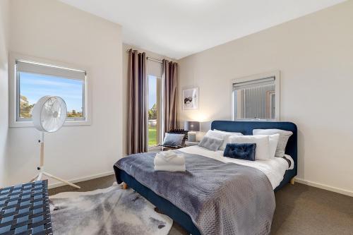 巴拉腊特特格思度假屋的卧室配有蓝色和白色的床和窗户。