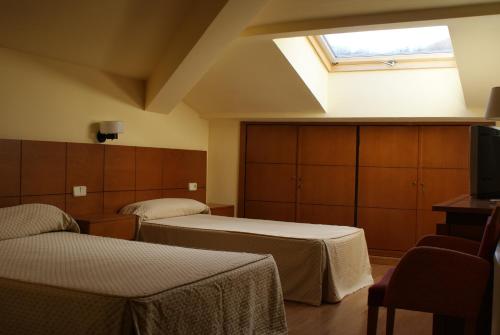 巴尼奥斯德蒙特迈奥尔巴尔内阿里奥坎大酒店的酒店客房设有两张床和天窗。