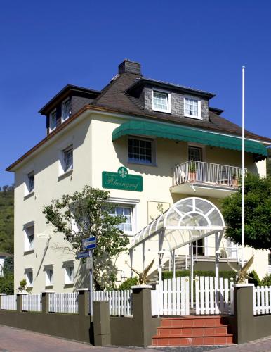 坎普-博尔恩霍芬Gästehaus Hotel Rheingraf的前面有白色围栏的白色建筑