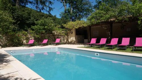 Saint-Jean-dʼAigues-Vives多民多汉木拜罗思住宿加早餐旅馆的一组粉红色的椅子和一个游泳池