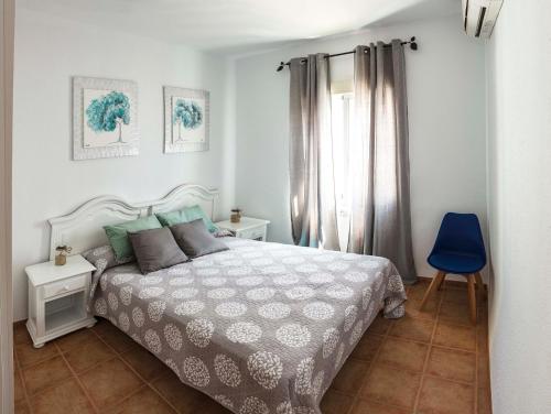 马塔拉斯卡尼亚斯Chalet en Matalascañas a 300 metros de la playa的一间卧室配有一张床和一张蓝色椅子