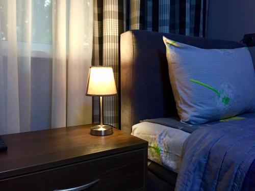 基辅Westend Hotel Kyiv的一间卧室配有一张床和一张带台灯的桌子
