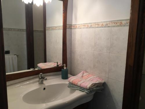 蒙特圣玛丽亚－蒂贝里纳CASA AZZURRA MONTE SANTA MARIA TIBERINA的浴室配有带镜子的盥洗盆和粉红色毛巾