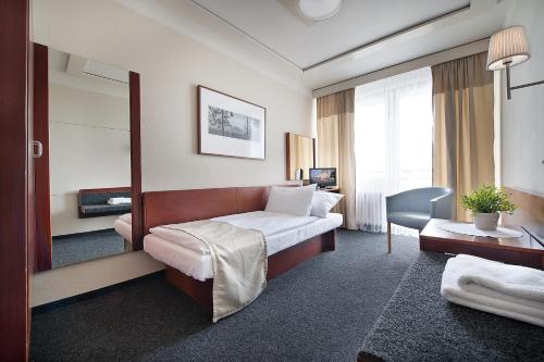 克拉德诺Retro Hotel Kladno的配有一张床和一张书桌的酒店客房