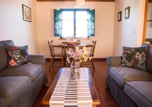 CamangoCasa Rural Camangu的客厅设有两张沙发和一张鲜花桌