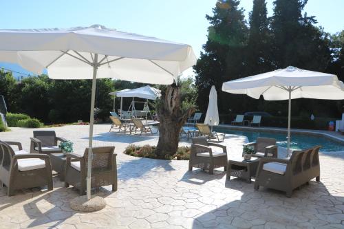 阿普索斯Summer Wine Friendly Resort的游泳池旁带椅子和遮阳伞的天井