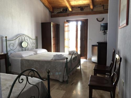 卡布拉斯Sa Crannaccia的一间卧室设有两张床、一把椅子和一个窗户。