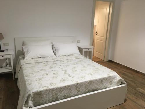 阿斯科利皮切诺L’Acerba B&B的白色卧室内的一张白色床,配有两张桌子