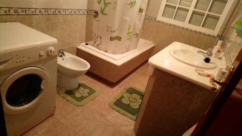 格罗韦Apartamento Lordelo的浴室配有卫生间水槽和洗衣机。
