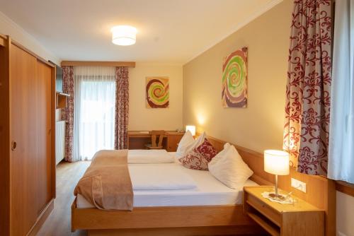 弗拉塔赫Alpenhotel Badmeister的酒店客房设有床和窗户。