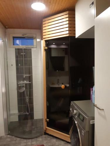波里Pieni moderni saunallinen kaksio keskustan lähellä的带淋浴和玻璃门的厨房