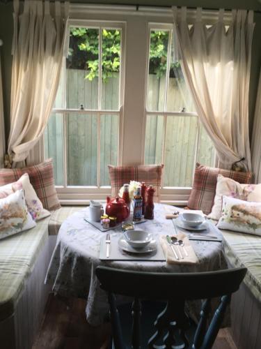 吉林汉姆Lodbourne House B&B的客厅配有桌子和2扇窗户