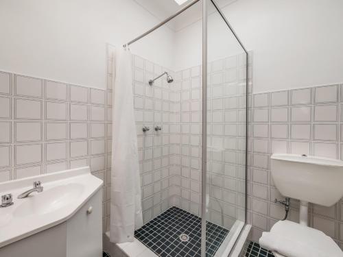 金德拜恩金德拜恩雪谷度假村的带淋浴和盥洗盆的白色浴室