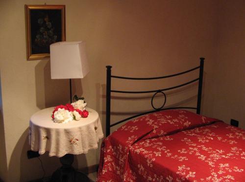 奥瓦达La Miseria的一间卧室配有一张床和一张鲜花桌子