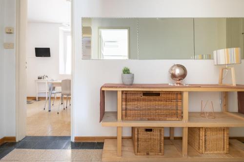 博洛尼亚Residenza Ariosto by Studio Vita的客厅配有桌子和镜子
