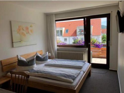 蒂宾根Gasthof ´s Gräbele的一间卧室设有一张床和一个大窗户