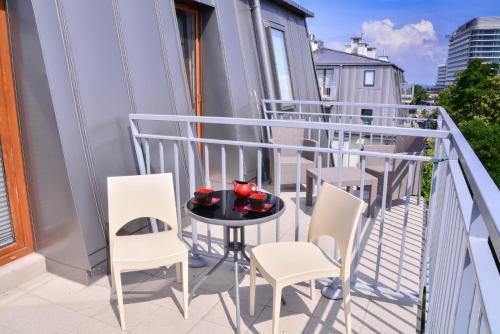 斯维诺乌伊希切Apartamenty na Wyspie - Aquamarina - Budynek A - B - C的阳台配有桌椅。