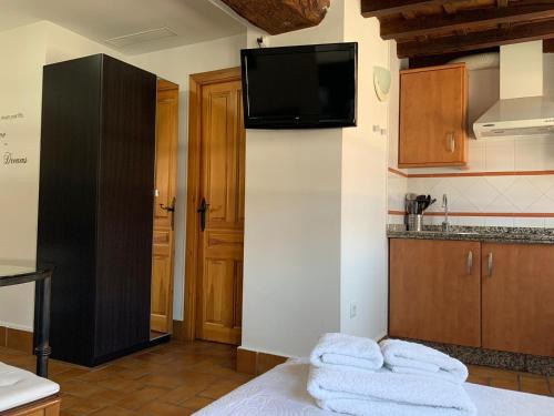 科尔多瓦Apartamento Corredera的厨房设有壁挂式电视,床上配有毛巾