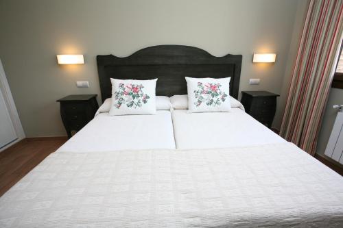CorduenteCASA RURAL MIRALTAJO的卧室配有一张带两个枕头的大白色床