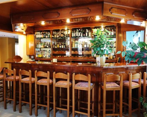 卡尔帕索斯Titania Hotel Karpathos的酒吧,酒吧有一大堆酒吧凳