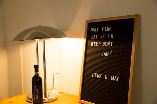 韦尔特Beej Potters的一瓶葡萄酒,旁边是一盏灯和标志