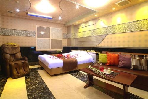 厚木Hotel GOLF II Atsugi (Adult Only)的一间卧室配有一张大床和一张沙发