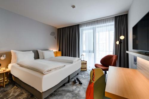 慕尼黑慕尼黑斯彻瓦宾美居酒店的酒店客房,配有床和电视