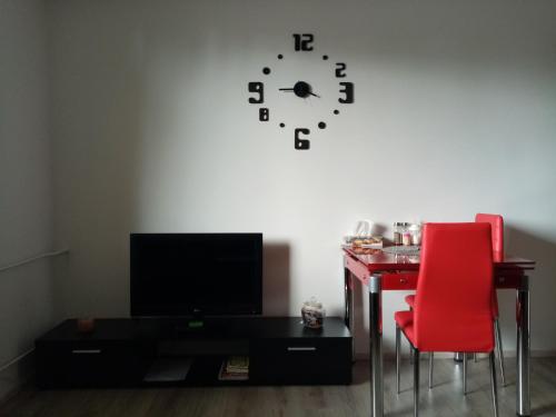 卡罗维发利apartmán Aneta的一间设有书桌和墙上的时钟的房间
