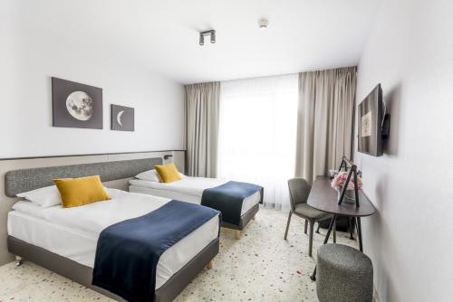 格丁尼亚安塔尔斯酒店的酒店客房配有两张床和一张书桌