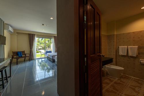 拉威海滩Blue Beach Grand Resort And Spa SHA Plus的浴室配有卫生间、盥洗盆和浴缸。