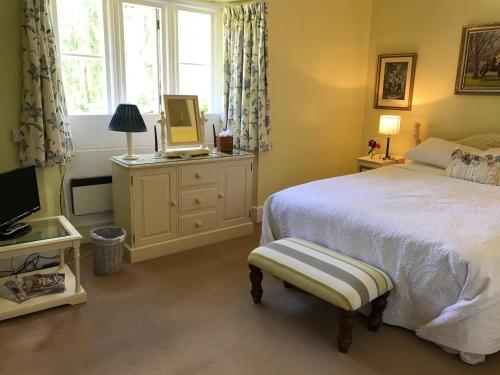 奇彭纳姆The Manor Farm Alderton的一间卧室配有一张床、一台电视和一个窗口