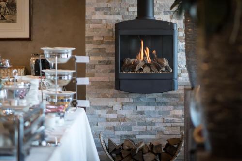 斯欣奥普赫尔赫维斯特兰德酒店的带壁炉的用餐室配有壁炉的桌子