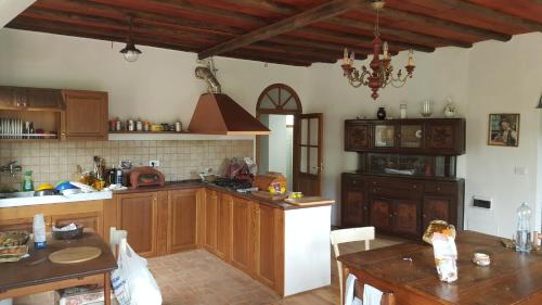 CamposascoRural House Rondini的一个带木制橱柜和桌子的大厨房