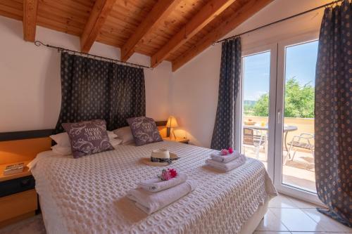 埃尔莫奈斯Villa Litsa的一间卧室设有一张床和一个大窗户
