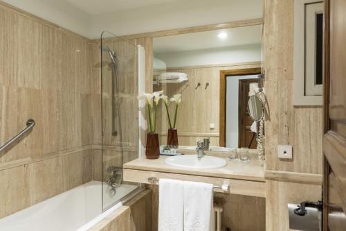 庞特维德拉蓬特韦德拉旅馆的一间带水槽、浴缸和镜子的浴室