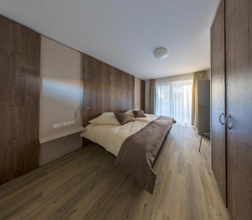 巴特武尔察赫Boarding & HOUSE T24的一间卧室设有一张大床和木墙