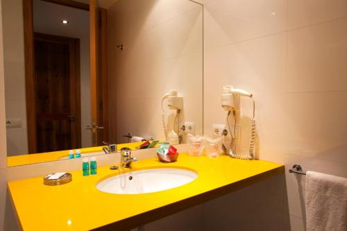 波连斯萨L'Host Boutique Rooms的浴室设有黄色水槽和镜子