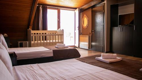 第比利斯纽麦泰基酒店的一间卧室配有两张床和一张婴儿床。