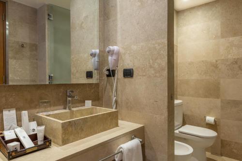 科金博Enjoy Coquimbo的一间带水槽和卫生间的浴室以及一部电话