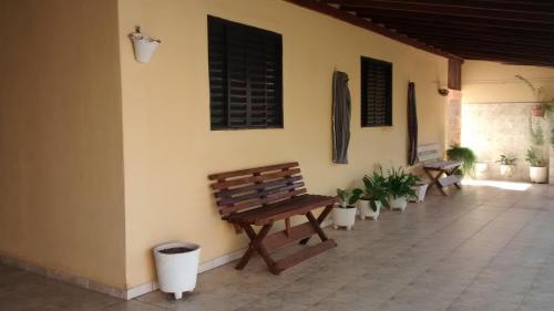 奥林匹亚Casa de Temporada Recanto Fazendinha的长凳坐在墙上,墙上有盆栽植物