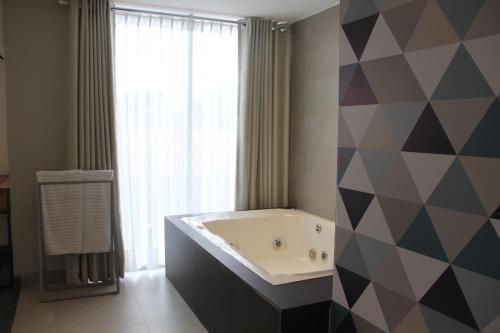 圣克鲁斯Hotel G的一间带大浴缸和大窗户的浴室