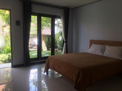 坎古巴厘岛满月旅馆的一间卧室设有一张床和一个大窗户