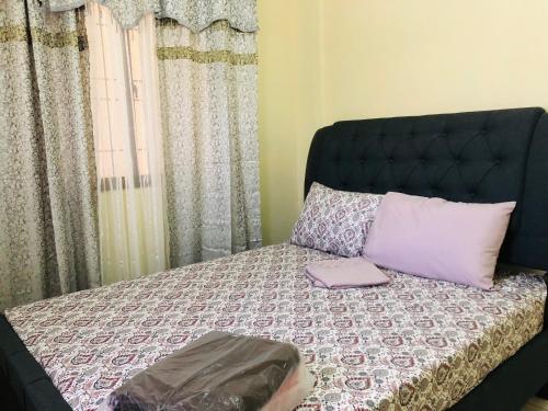 NaicLuzville Residences - C5的一张带黑色床头板和枕头的床